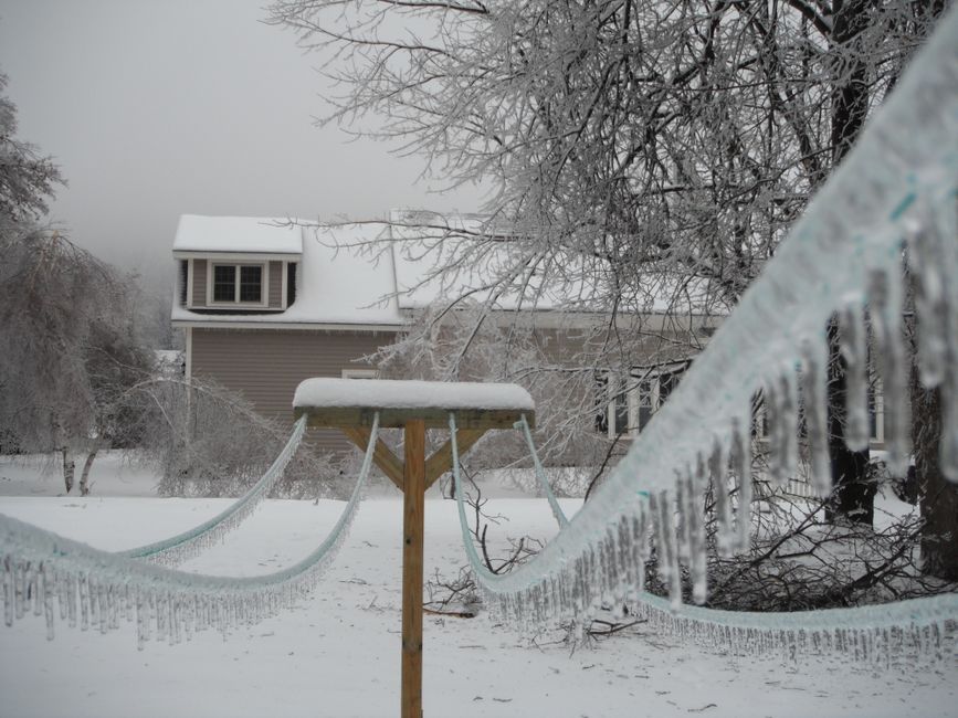 Snow-covered rural property with an exposed well line.